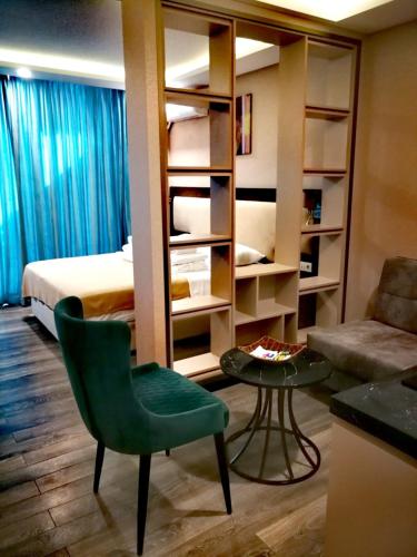 a room with a bed and a chair and a table at Luxury Hotel Suite Apartment in Batumi