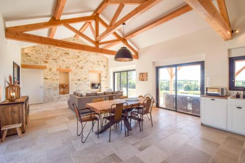 a kitchen and dining room with a table and chairs at Domaine d'Essendiéras in Saint-Médard-dʼExcideuil