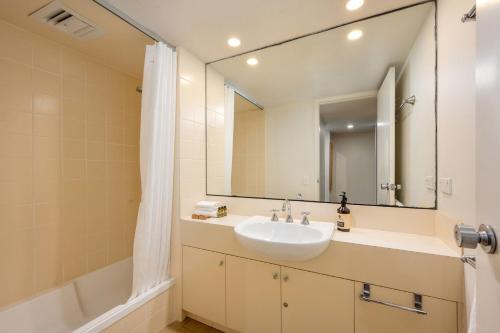 a bathroom with a sink and a mirror and a tub at Squatters Run Unit 11 in Thredbo