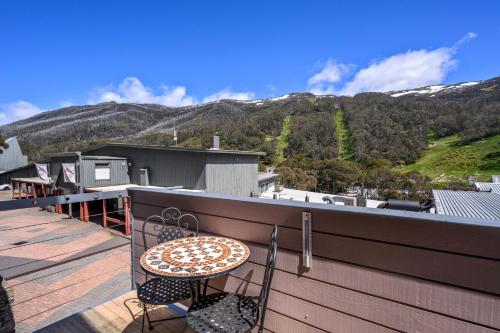 a patio with a table and chairs on a balcony at Squatters Run Unit 11 in Thredbo
