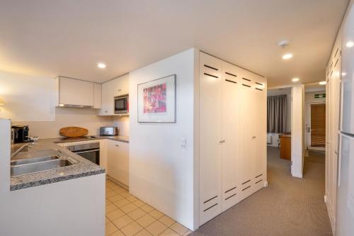 a kitchen with white cabinets and a sink at Squatters Run Unit 11 in Thredbo
