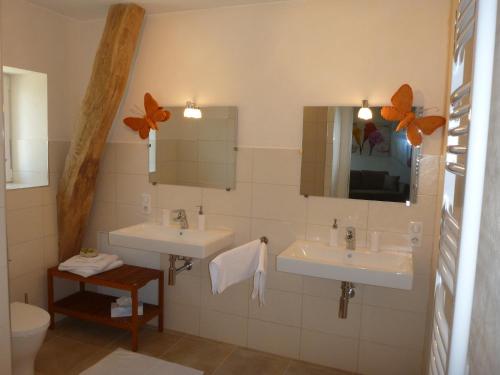 une salle de bain avec deux lavabos et un miroir dans l'établissement Domaine du Papillon, à Lesparre-Médoc