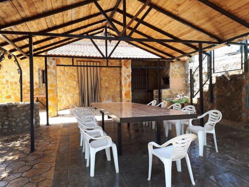 una gran mesa de madera y sillas bajo un pabellón en Casa El Tío Patricio, en Trujillos