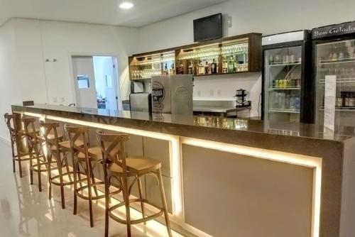 a bar with a row of stools in a kitchen at Tri Hotel Executive Indaial in Indaial