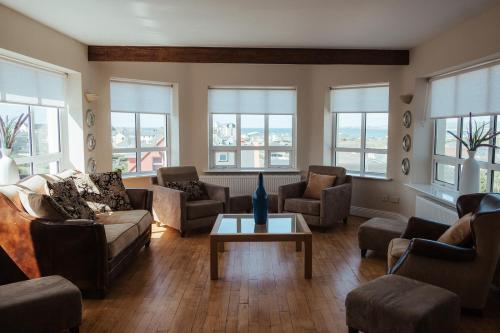 a living room with a couch and chairs and a table at Lehinch Lodge in Lahinch