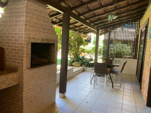 a patio with a brick fireplace and a table and chairs at Pousada Solar dos Girassóis in Bombinhas