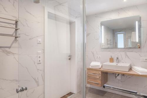 La salle de bains est pourvue d'une douche, d'un lavabo et d'un miroir. dans l'établissement Ferienwohnung Zugspitze, à Ehrwald