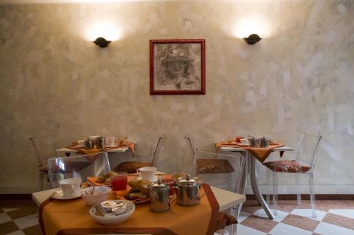 uma sala de jantar com duas mesas com comida em Art Hotel Al Fagiano em Pádua