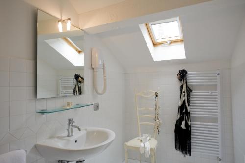 a white bathroom with a sink and a mirror at Art Hotel Al Fagiano in Padova