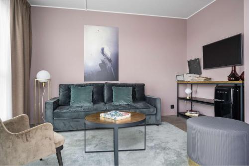 a living room with a couch and a table at Best Western Plus Hus 57 in Ängelholm