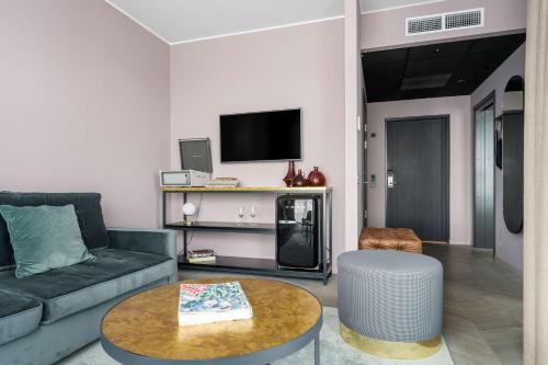 a living room with a couch and a table at Best Western Plus Hus 57 in Ängelholm