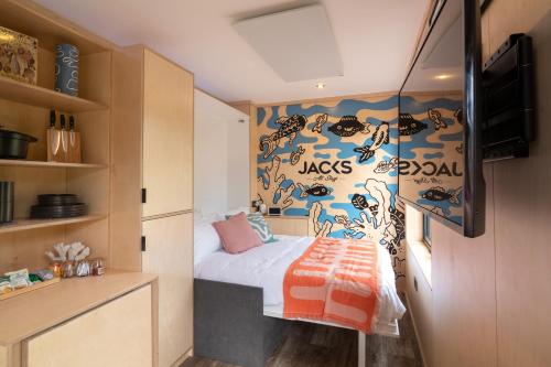 um pequeno quarto com uma cama e uma parede com macacos em The Reef - Unique Cabin in Millport em Millport