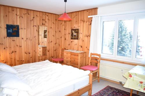a bedroom with a bed and a wooden wall at Ursina (301 Sh) in Sporz