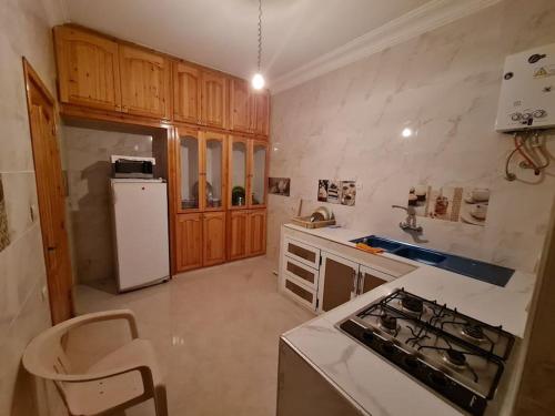 a kitchen with a stove and a white refrigerator at Appartement à louer in Larache