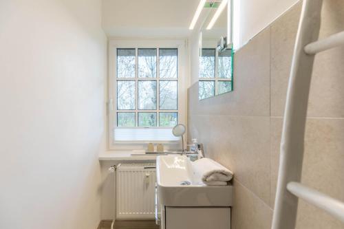 a bathroom with a sink and a window at Seestern in Vollerwiek