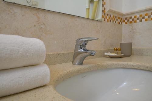łazienka z umywalką z kranem i ręcznikami w obiekcie Elbamar Marina Di Campo w mieście Marina di Campo