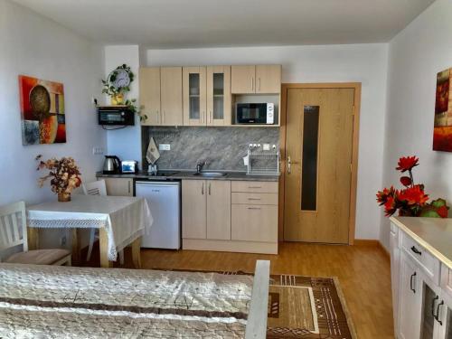a kitchen with white cabinets and a table and a counter at Supreme appartment in Balchik