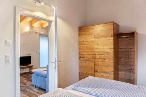 um quarto com uma cama e um armário de madeira em Ferienwohnung Grubig em Ehrwald