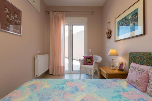 a bedroom with a bed and a sliding glass door at Villa Kleanthi in Ambelákion