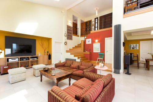 a large living room with couches and a tv at Villa Kleanthi in Ambelákion
