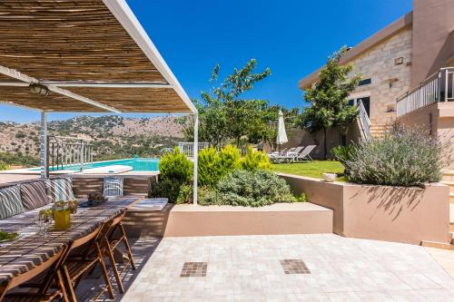 a patio with a table and a pool at Villa Kleanthi in Ambelákion