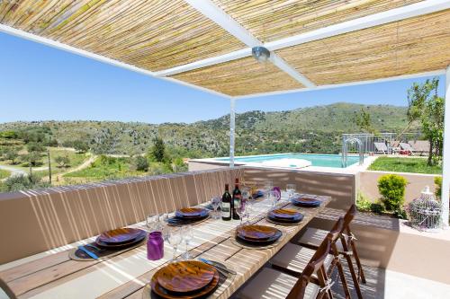 a table with plates and wine glasses on a patio at Villa Kleanthi in Ambelákion