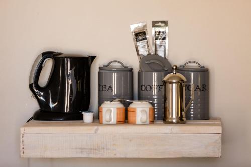 a wooden shelf with a group of appliances on it at Elegant Desert Lodge in Sesriem