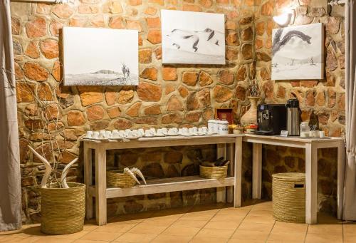 a stone wall with two tables in a room at Elegant Desert Lodge in Sesriem