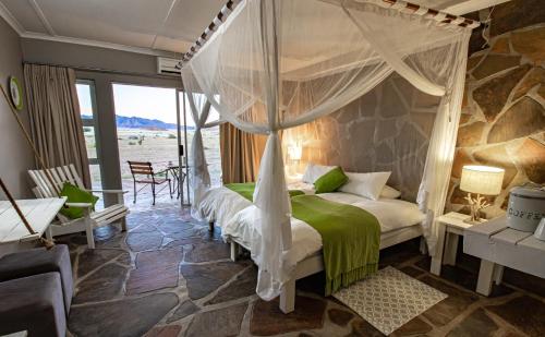 a bedroom with a bed with a canopy at Elegant Desert Lodge in Sesriem