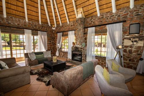 a living room with couches and a brick wall at Elegant Desert Lodge in Sesriem