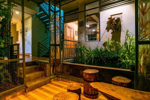a room with wooden floors and stools in a building at Mistletoe Homestay & Cafe in Munnar
