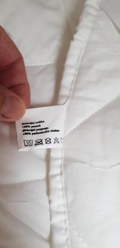 a person holding a piece of white fabric with a tag on it at AppPrusnik in Ljubljana