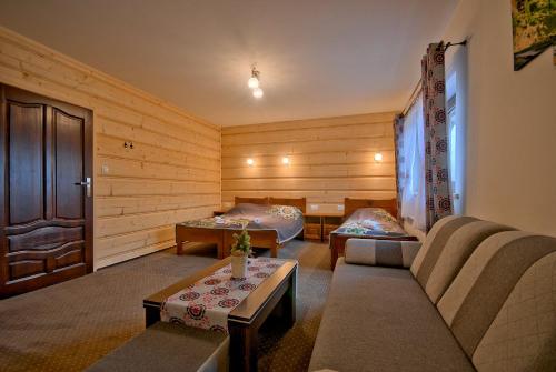 a living room with two beds and a couch at POKOJE BUCKI in Bukowina Tatrzańska