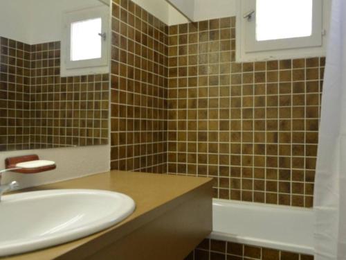 une salle de bain avec un lavabo et un miroir dans l'établissement Appartement 3 pièces, piscine, à 100m de la plage, avec garage privatif, Cap d'Agde - FR-1-249-192, au Cap d'Agde