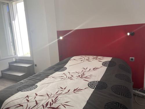 Ce lit se trouve dans une chambre dotée d'un mur rouge. dans l'établissement Studio Mezzanine - 4 pers, Piscine, Terrasse, Cap d'Agde - FR-1-249-311, au Cap d'Agde