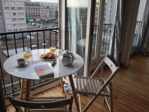 une table avec une assiette de nourriture sur un balcon dans l'établissement Magnifique appartement à 5 min de Paris et 10 min de l'aéroport d'Orly, à Choisy-le-Roi