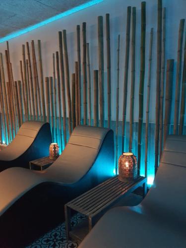 two benches in front of a bamboo wall with lights at Hotel Smeraldo in Lazise