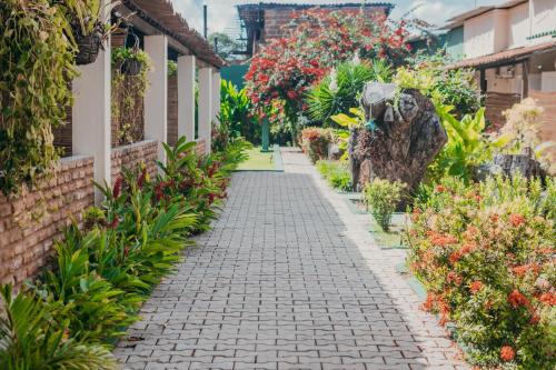 a walkway in a garden with flowers at Free! Hostel Vila in Pipa