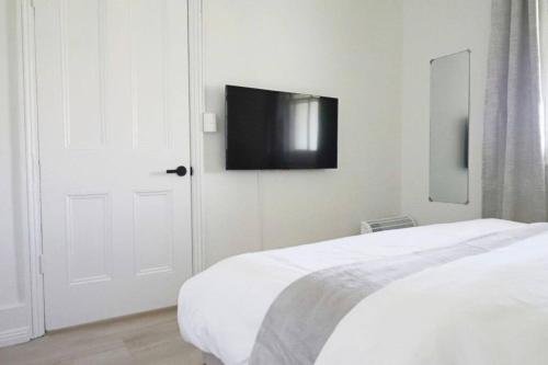 a bedroom with a bed and a tv on the wall at The Modern Victorian 200 metres from CBD in Bathurst