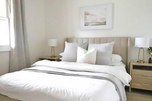 a bedroom with a large bed with white sheets and pillows at The Modern Victorian 200 metres from CBD in Bathurst