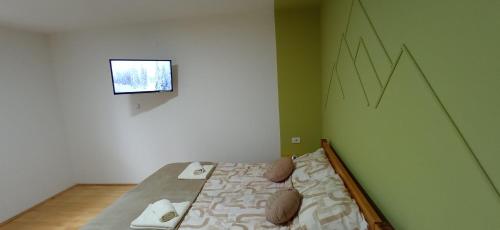 a bed in a room with a green wall at KovacInalux Apartmani in Pale