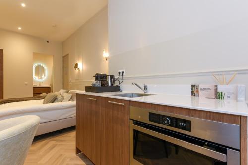 una cocina con fregadero y una cama en una habitación en Novallure City Centre, en La Haya