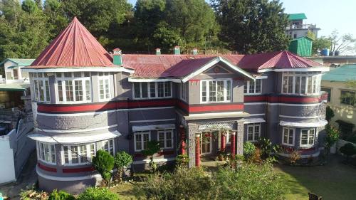 a large house with a red roof at Solan Retreat in Solan