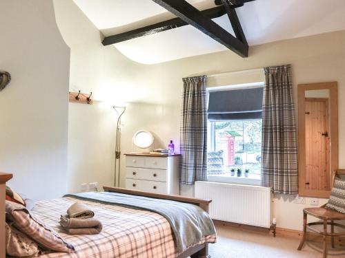 a bedroom with a bed and a window at High Dale Cottage in Bellerby
