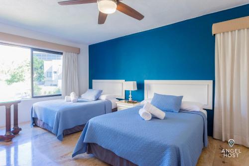 a blue bedroom with two beds and a ceiling fan at Private Villa Complex with Pool in Zona Hotelera in Cancún