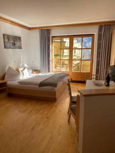 a bedroom with a bed and a large window at Landhaus Rosengartl Krimml in Oberkrimml