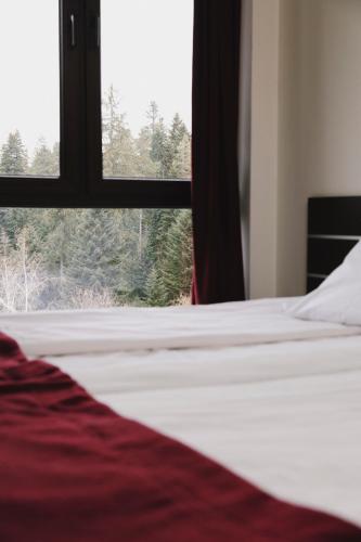 a bedroom with a bed and a window with trees at Borovets Green Hotel in Borovets