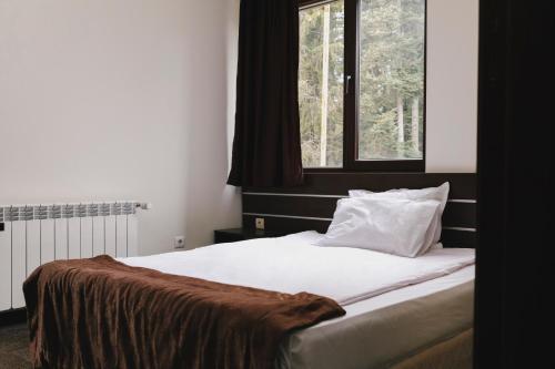 a bedroom with a large bed with a window at Borovets Green Hotel in Borovets