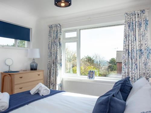 a bedroom with a bed and a large window at Blue Horizon in Sidmouth