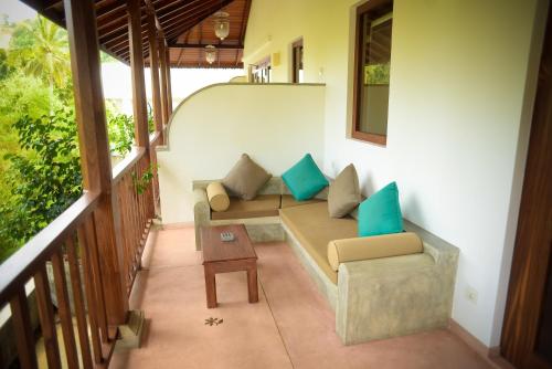 a living room with a couch and a table at Kingfisher Bamboo Garden Villa in Unawatuna